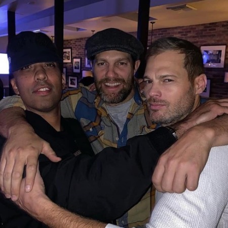 George Stults with his friends is posing for the photo.